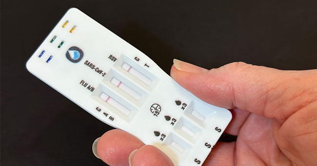 A hand holds a RAT test.