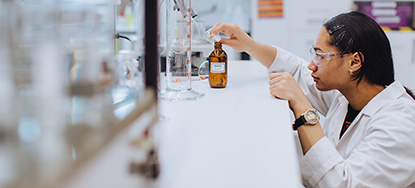 Person in a research lab measuring liquid image