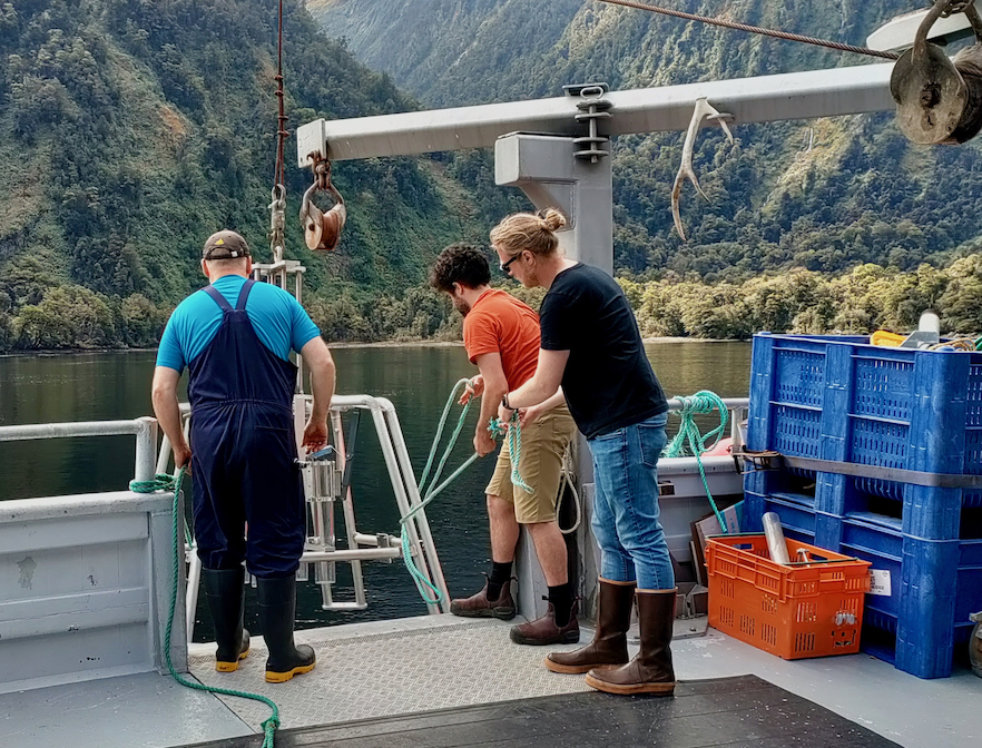 Retrieving seafloor sediment samples from a boat deck in Fiordland