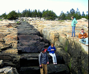Students examining a 3m wide intrusive basalt dike at Acadia National Park in Maine, USA