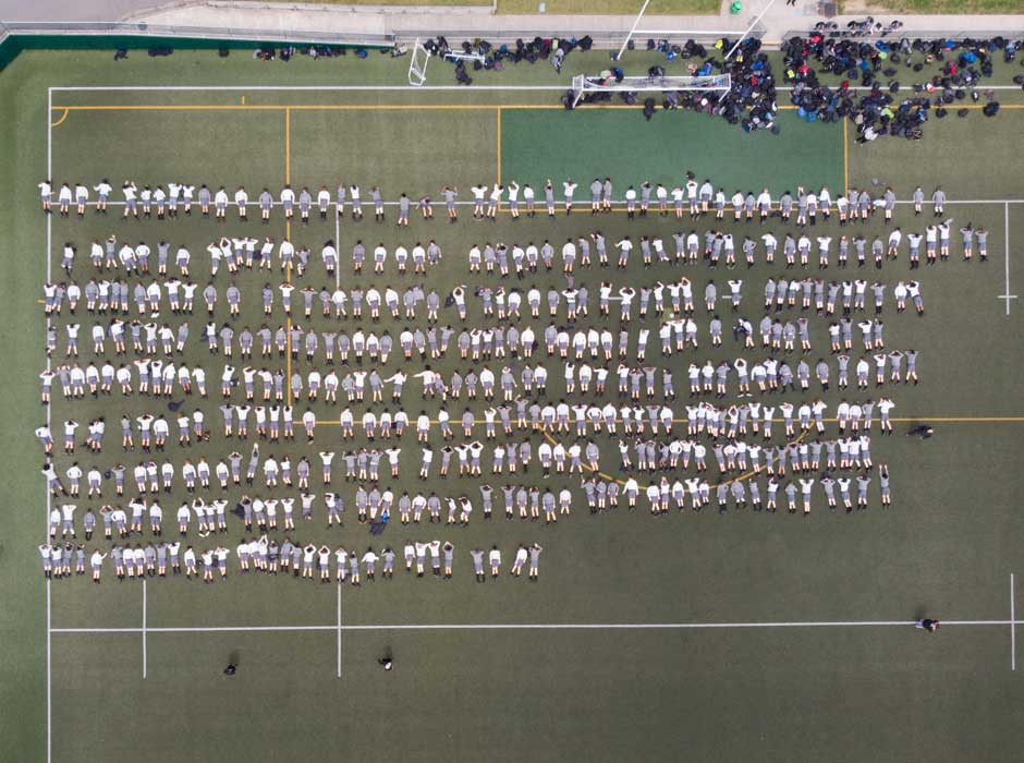 Birds eye view of 480 people lying on the ground in 9 rows 