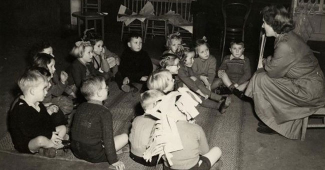 Female teacher reading story to children