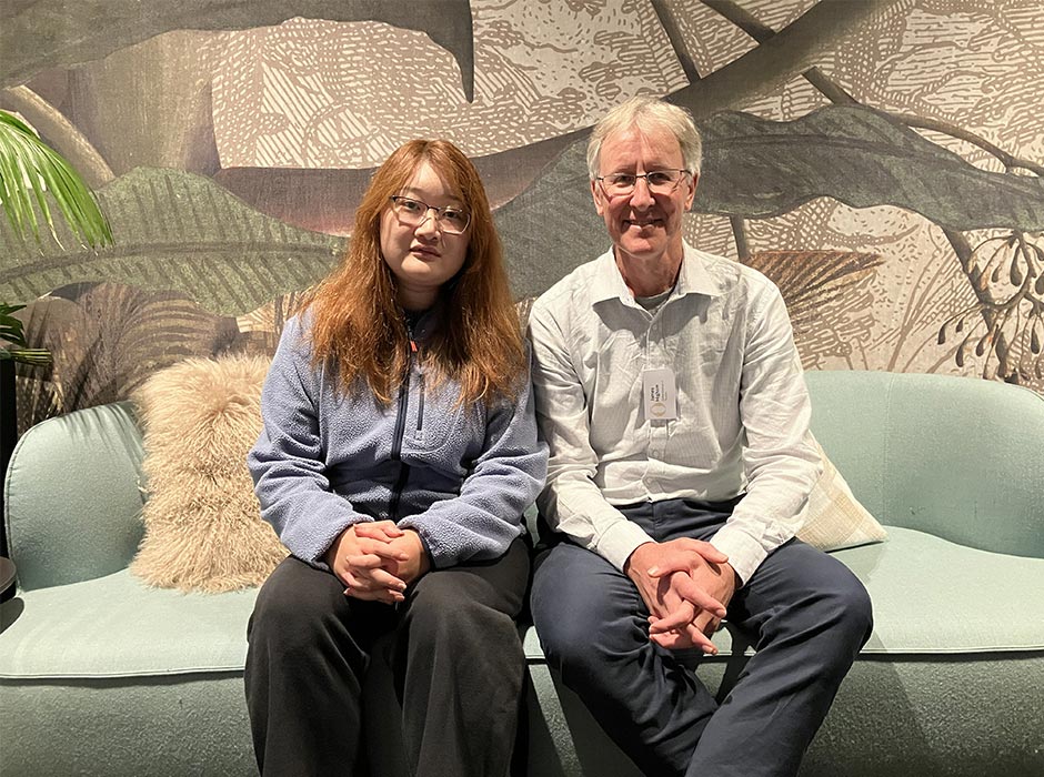 A woman and a man sit together on a sofa.