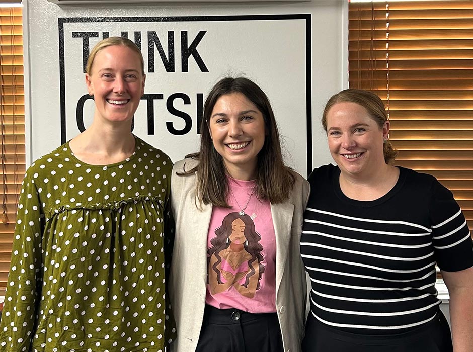 Three women pose for a photo.