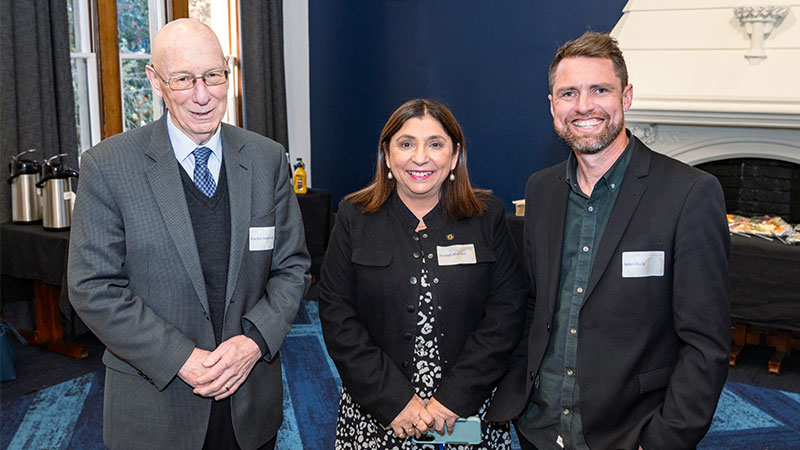 Two men and a women are pictured at an event.