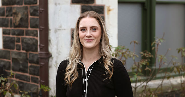 Ashlee Berryman pictured outside a University of Otago stone building.
