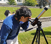 Student looking through telescope.