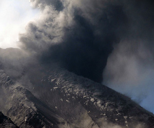 Bombardment after an explosion lifting puffs of ash and dust into the wind from the outer slopes of the crater at Sakurajima volcano, Japan.