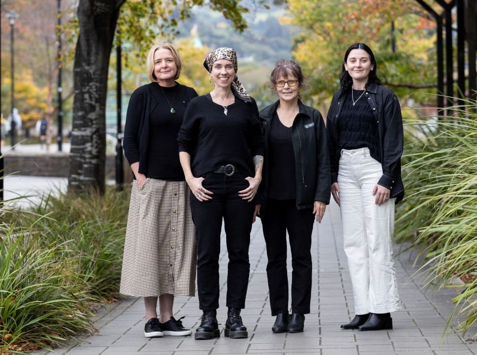 Four women standing on a footpath 
