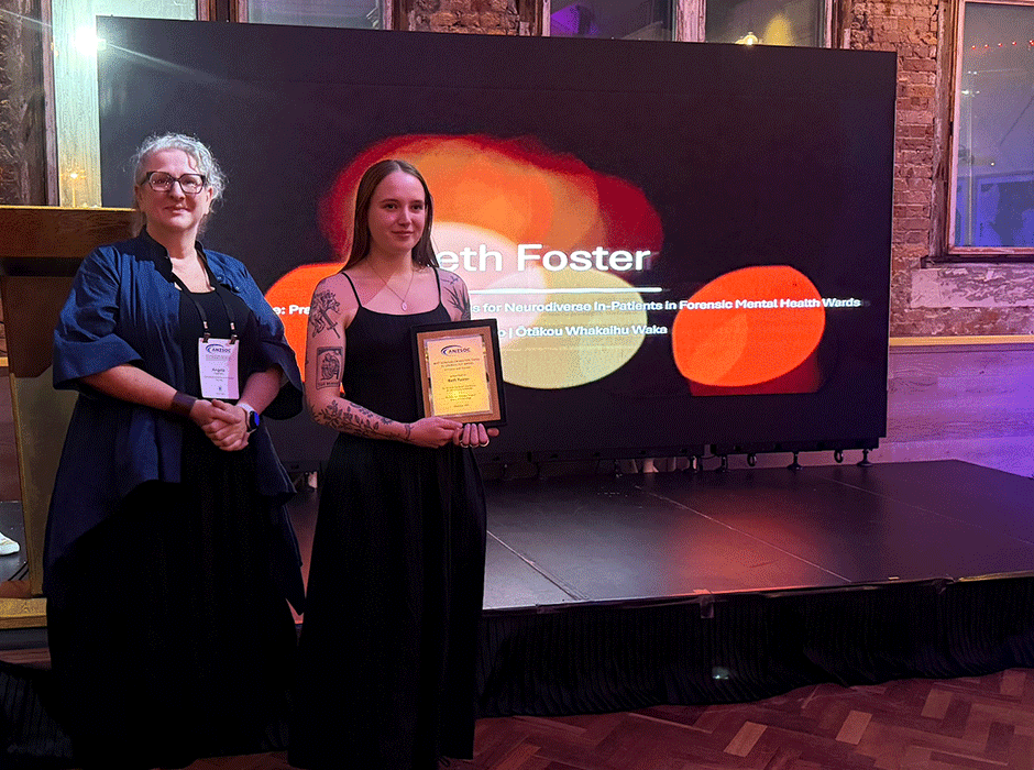 Two woman standing, one holding a certificate 