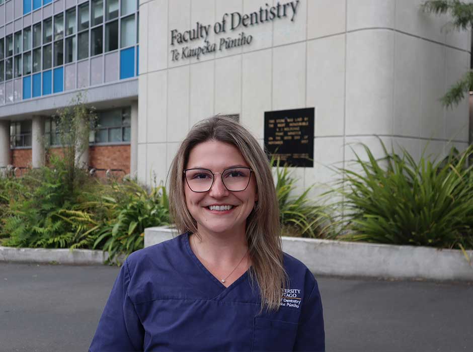 a woman standing in front of the dentistry school building 