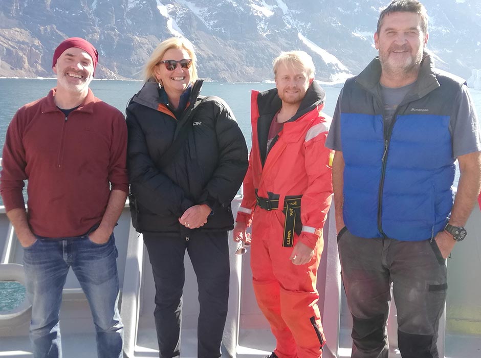 Three men and one woman on a research vessel