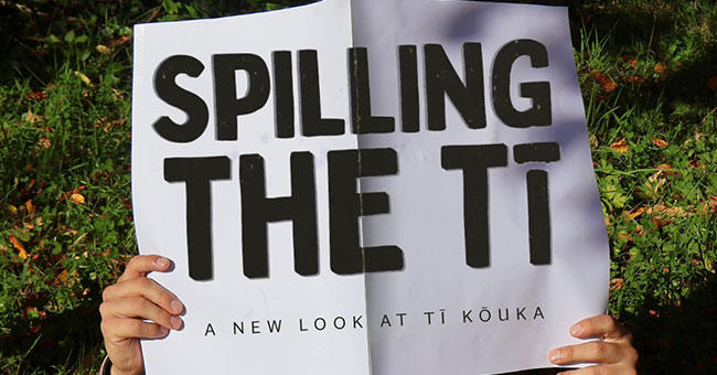 Pic of a person's hand holding a blank newspaper with the words spilling the ti written across the paper.