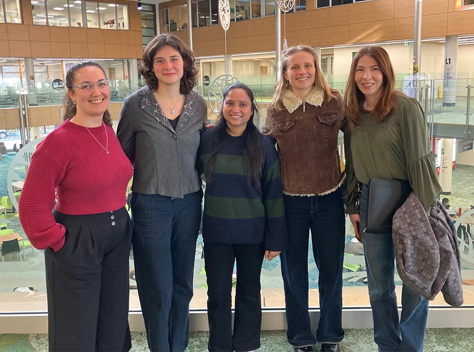 A group of women pose for a photo in the Business School.