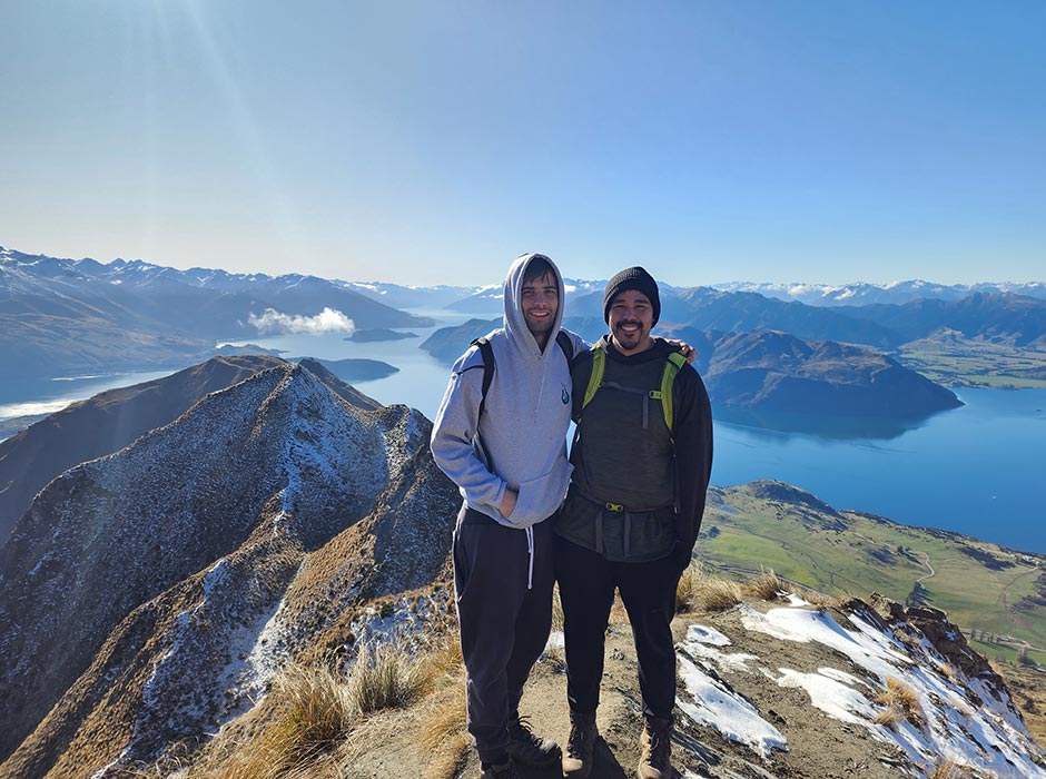 Two men standing at the top of Roy's Peak, near Wanaka