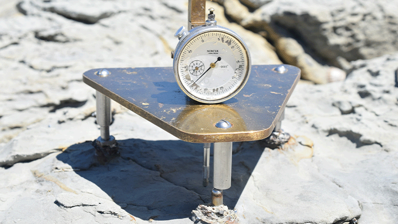 a close-up of a micro-erosion metre sitting on rocks