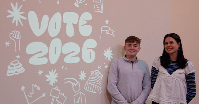 students standing in front of Vote 2026 sign