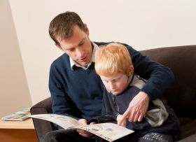 Father reading to son in Assoc Prof Elaine Reese's Research Lab