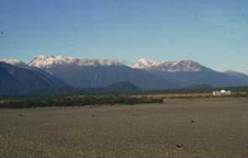 View lookin southeast across Haast River with ridges extending from the mountains with flat tops