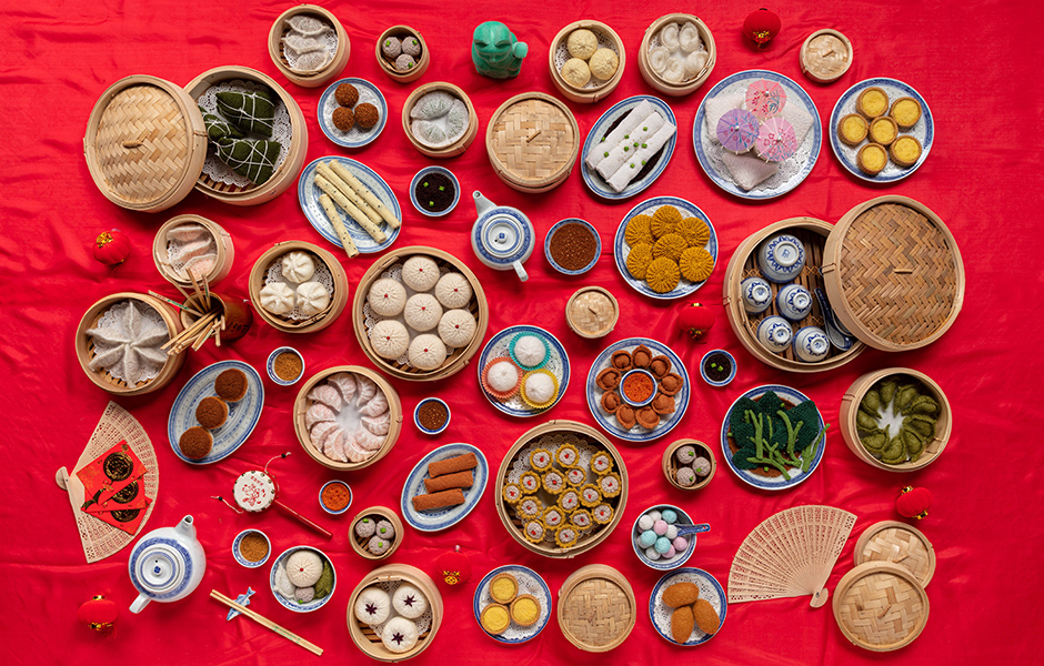 Variety of knitted Yum Cha foods on red table cloth.