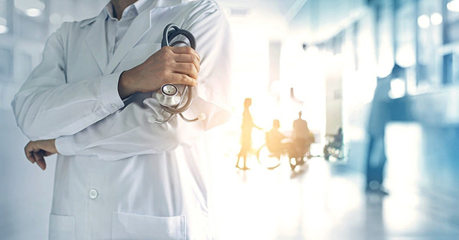 Doctor holding stethoscope in hospital corridor thumbnail