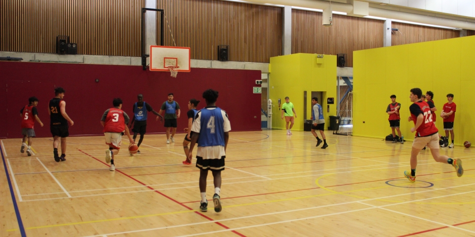 Two teams competing at basketball on the court. The figures are blurry because of the game's frenetic pace!