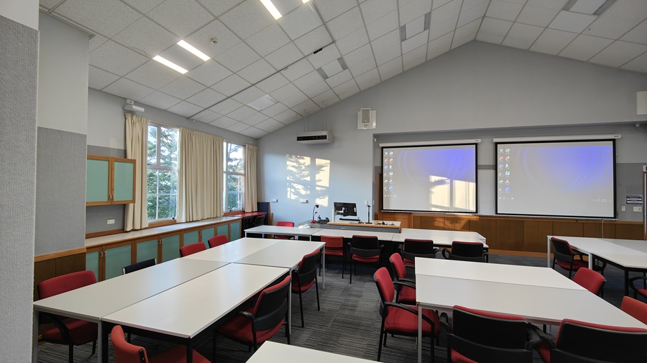 A view of Ōwheo building seminar room 206, showing tables and chairs in groups