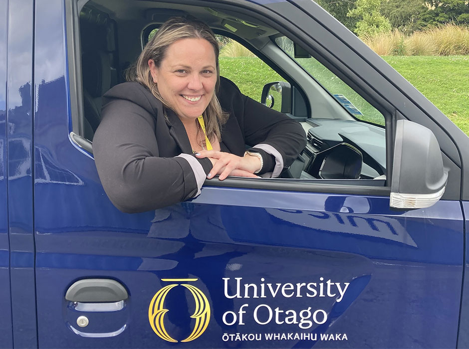A woman seated in a navy blue car 