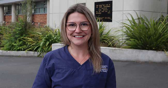 a woman standing in front of the dentistry school building 
