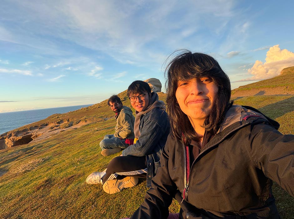 A women and two men sitting at Tunnel Beach