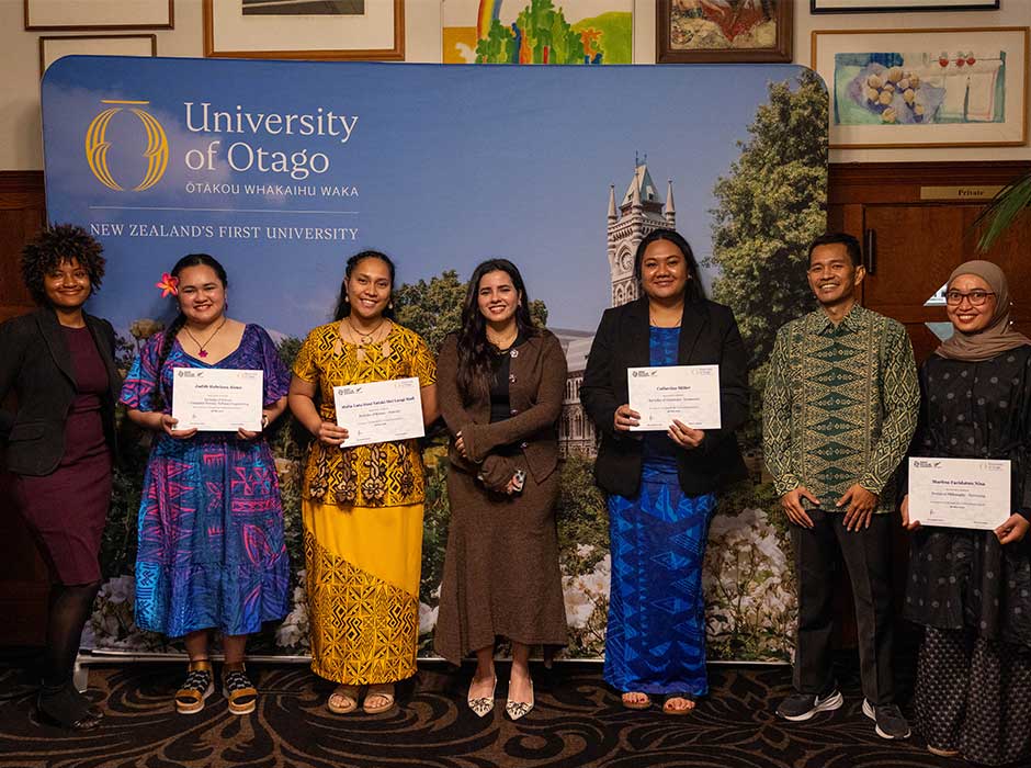 seven people standing in a room next to each other, some holding certificates