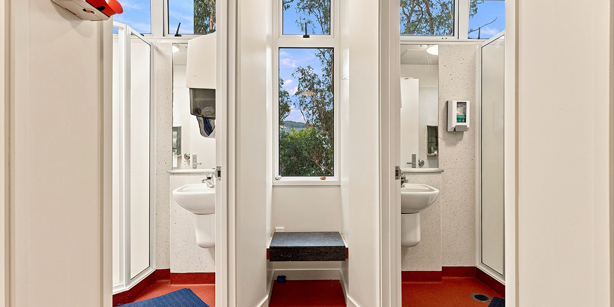 Shared bathroom space with individual bathroom and shower cubicles