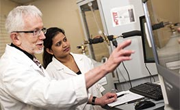 Student and teacher in lab pointing to screen