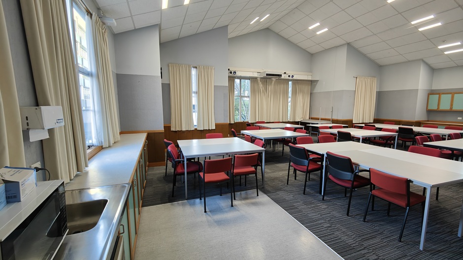 A view of Ōwheo building seminar room 206, showing tables and chairs in groups