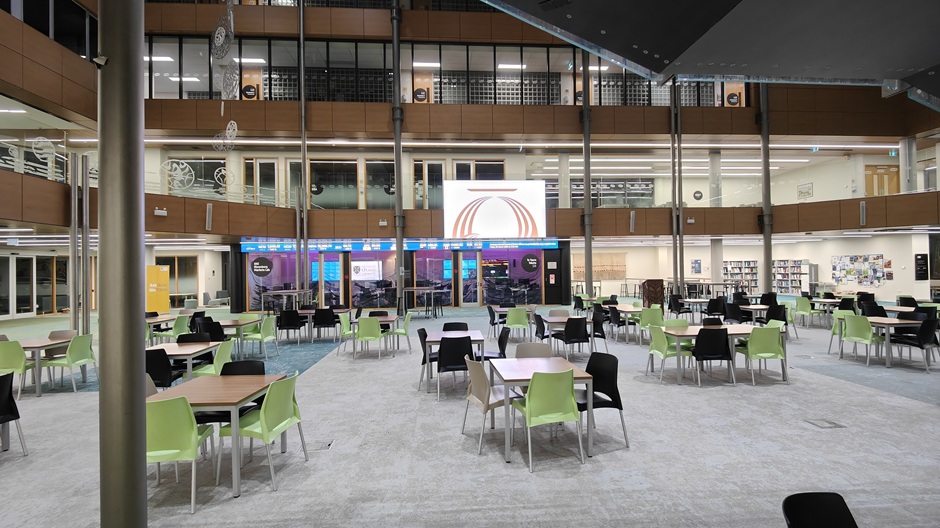 View of Otago Business School atrium, showing tables and chairs in groups