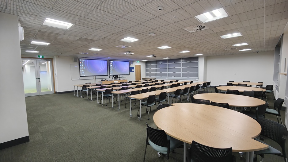 View of Otago Business School room G02, showing tables and chairs in rows and groups