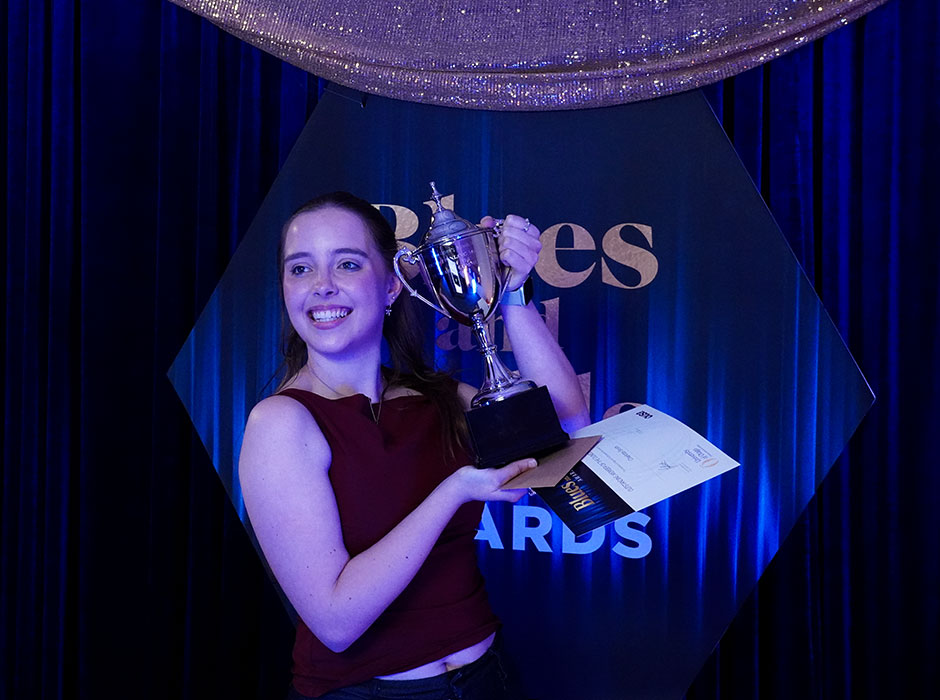 A person holding a trophy on stage 