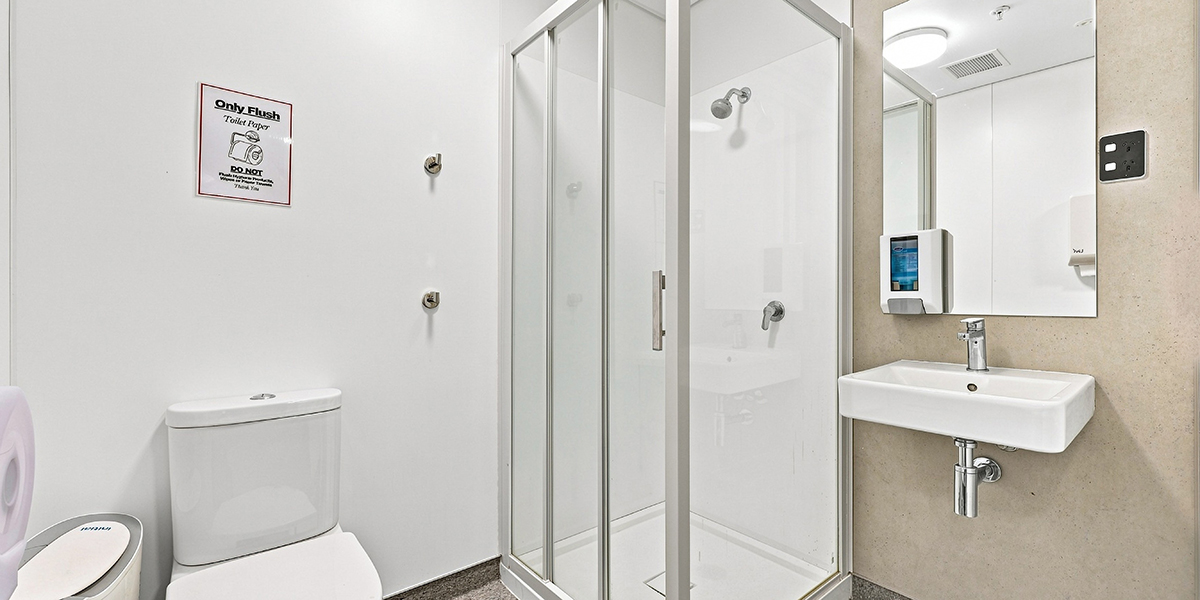 Bathroom cubicle with toilet, shower and sink.