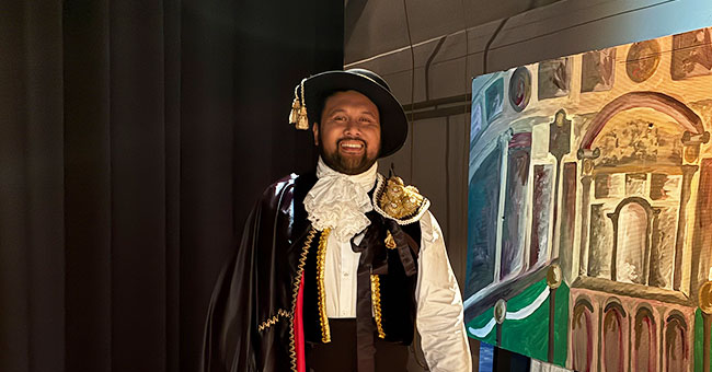 A man dressed in costume is pictured backstage at an opera.