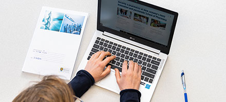 Pharmacy student browsing the pharmacy website on a laptop