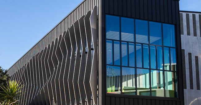 External view of the performing arts facility a dark clad cubist building with vertical sculptural fins along one side