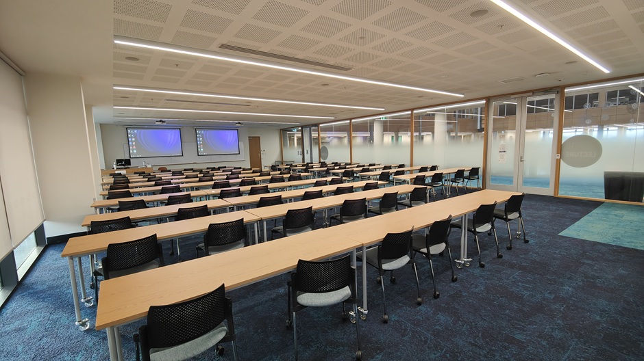 View of Otago Business School room 117, showing rows of tables and chairs