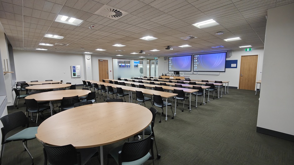 View of Otago Business School room G02, showing tables and chairs in rows and groups