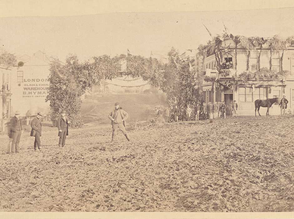 A black and white photo of the Octagon, Dunedin in 1863, a few people, lots of mud and a horse