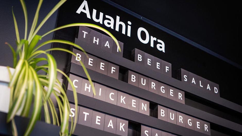 A section of the wall menu at Auahi Ora cafe, listing: Thai beef salad, beef burger, chicken burger, steak sandwich