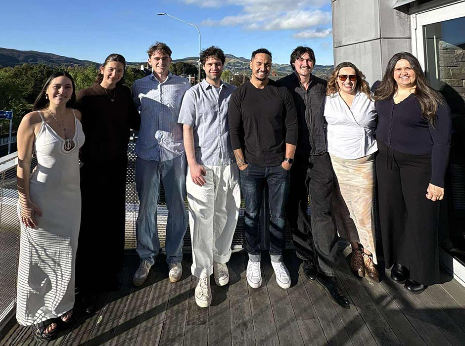 A group of people - University staff and students - standing on a balcony.