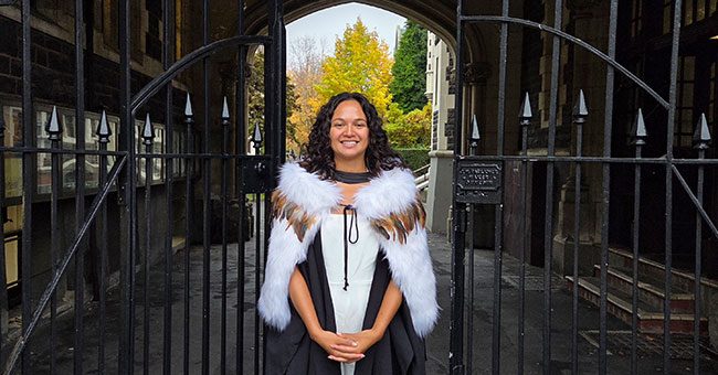 A young woman poses in her graduation wear.