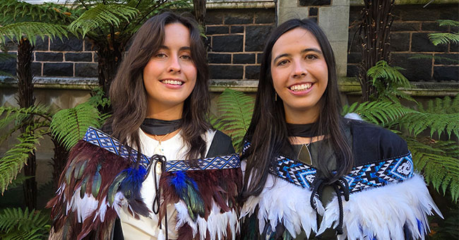 Two female graduates wearing tradition Māori korowai