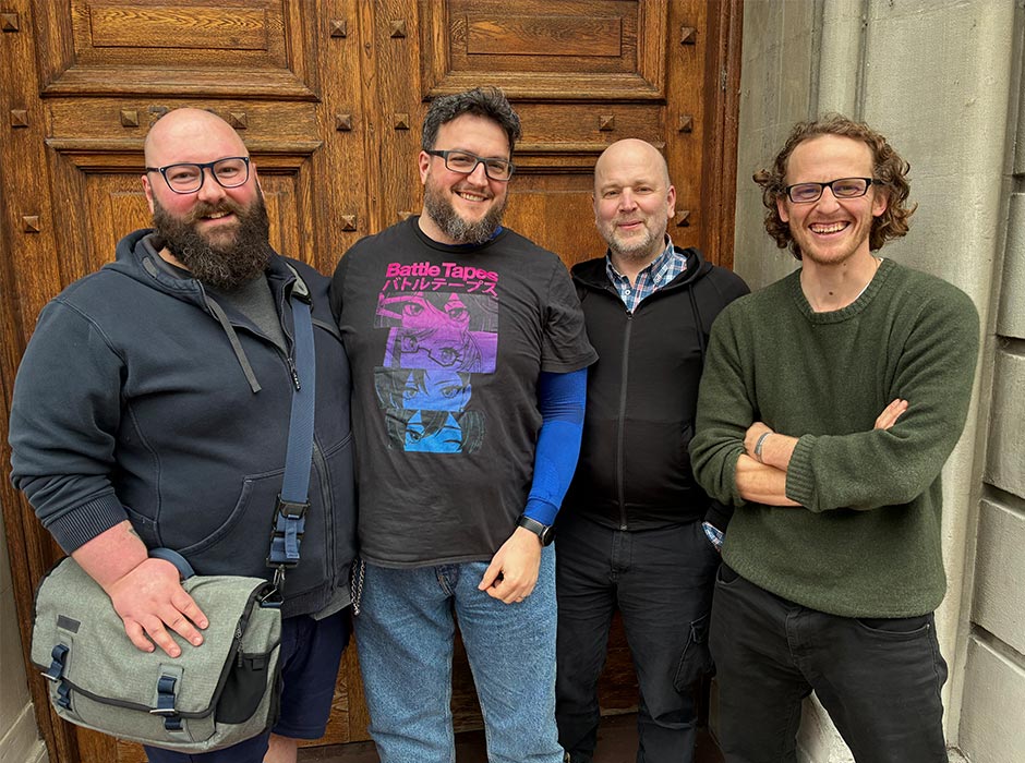 Four men pose for a photo outside the Zoology Department's Marples Building.