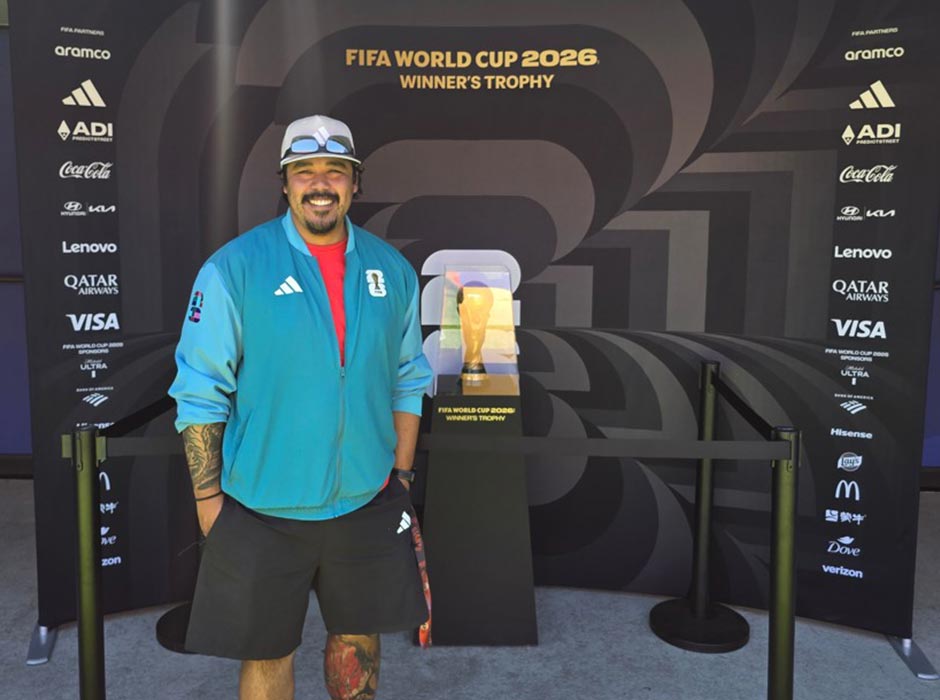 Man standing in front of the FIFA World Cup trophy